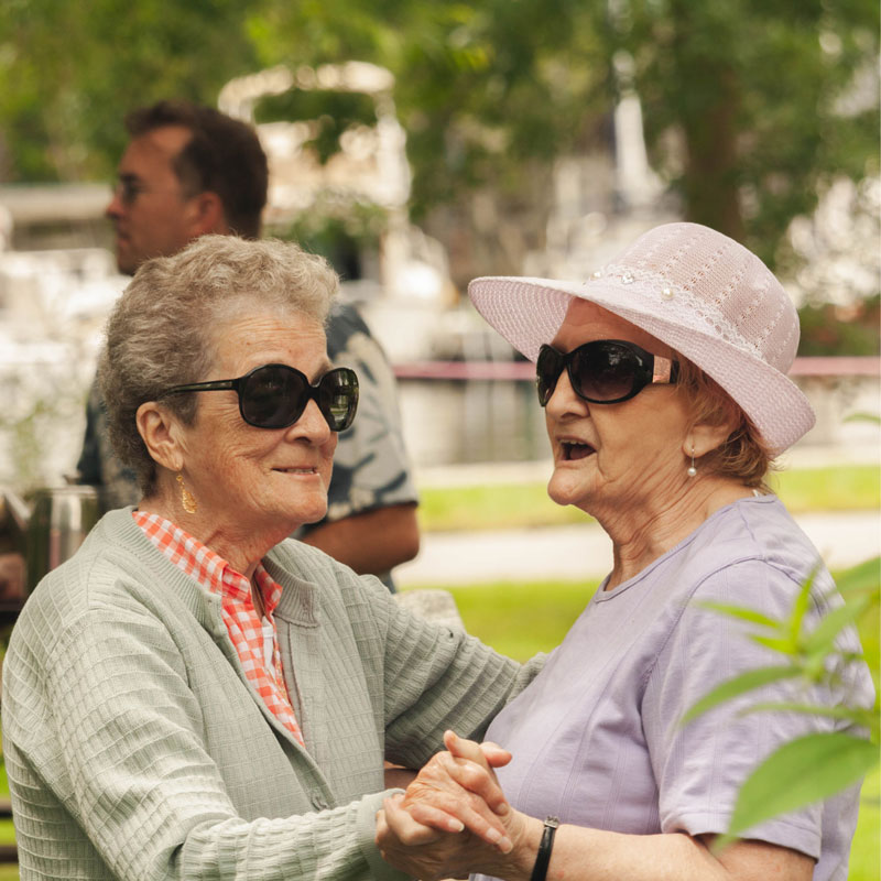 Two female older adults dancing together