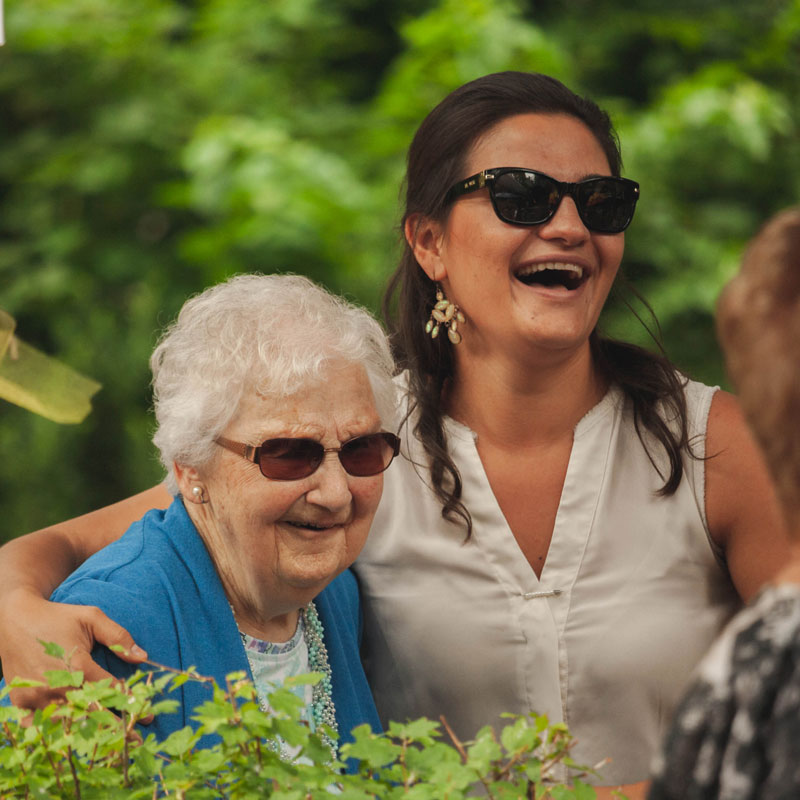 Older women smiling with a caregiver